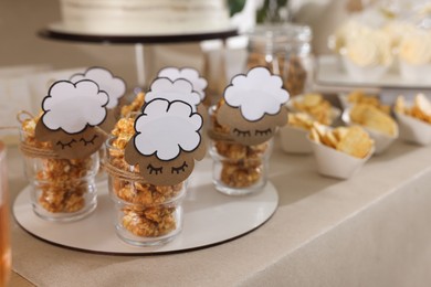 Tasty treats on table in room decorated for baby shower party