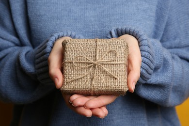 Photo of Woman in blue sweater holding Christmas gift box, closeup