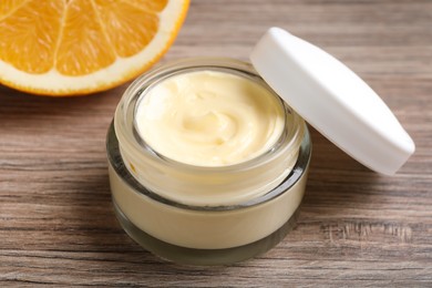 Photo of Jar of body cream on wooden table, closeup