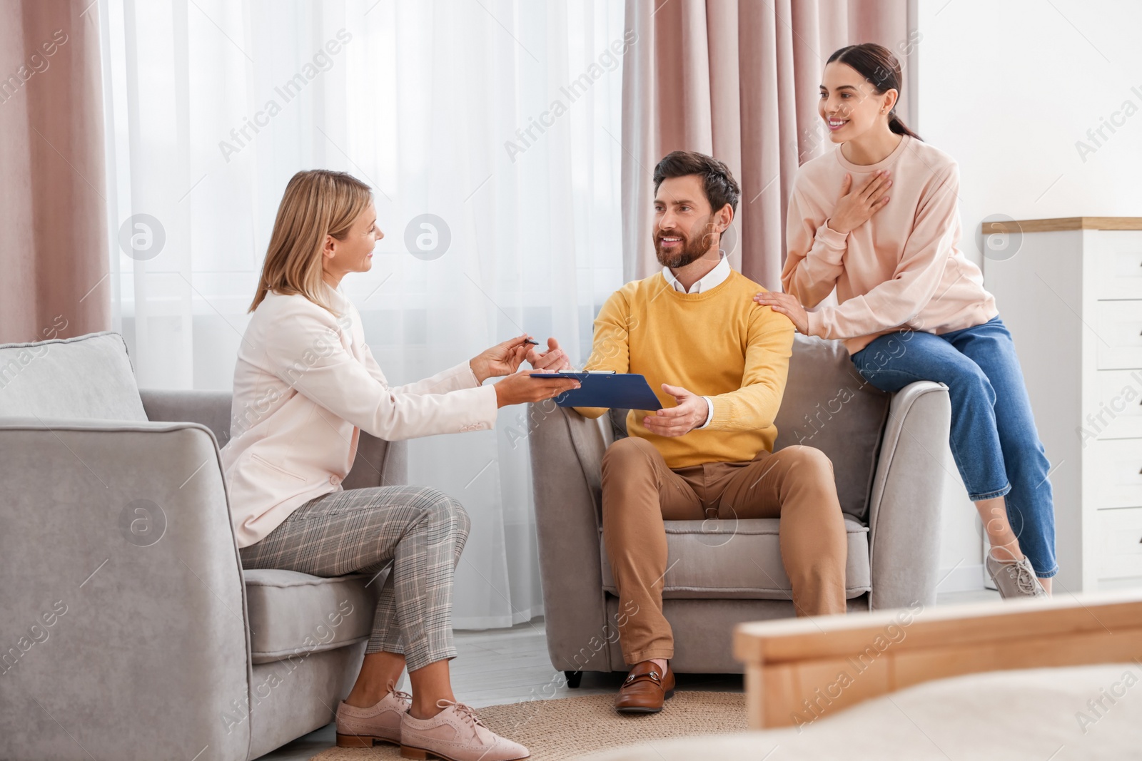 Photo of Real estate agent and couple signing contract in new apartment