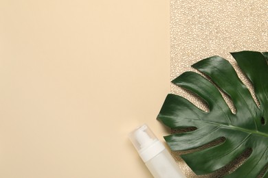 Photo of Bath accessory. Bottle of cosmetic product and palm leaf on beige background, top view. Space for text