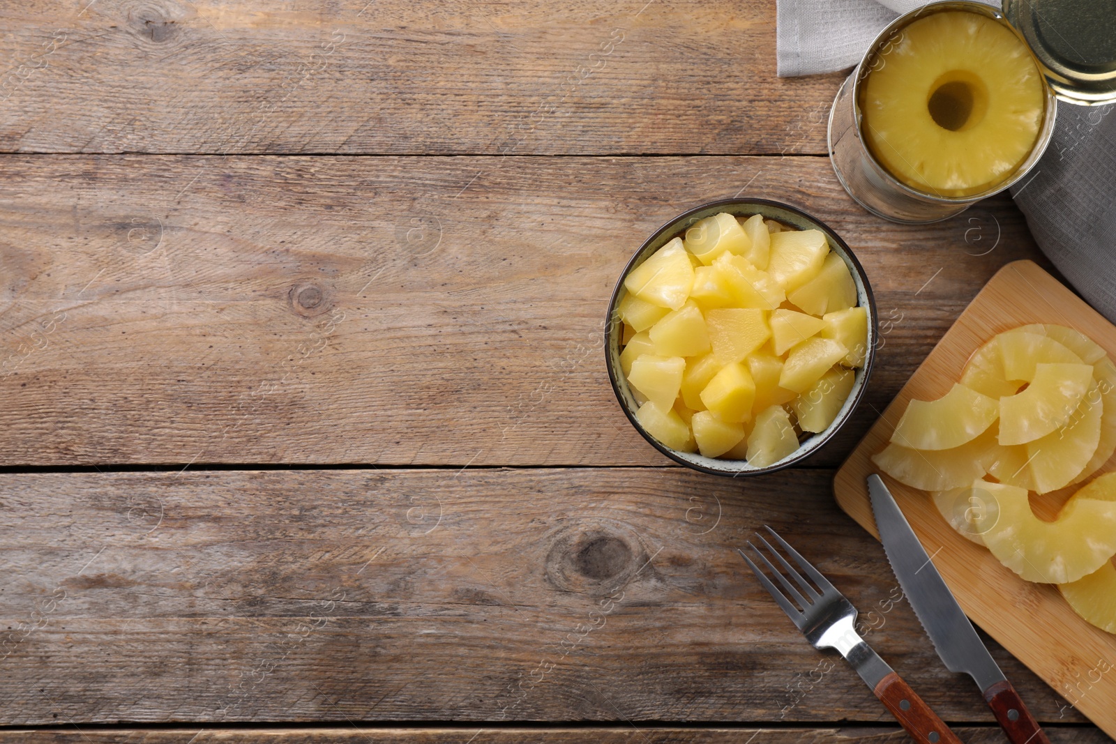 Photo of Flat lay composition with canned pineapple on wooden table. Space for text