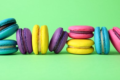 Delicious fresh colorful macarons on green background