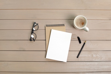 Flat lay composition with office stationery and cup of coffee on wooden table