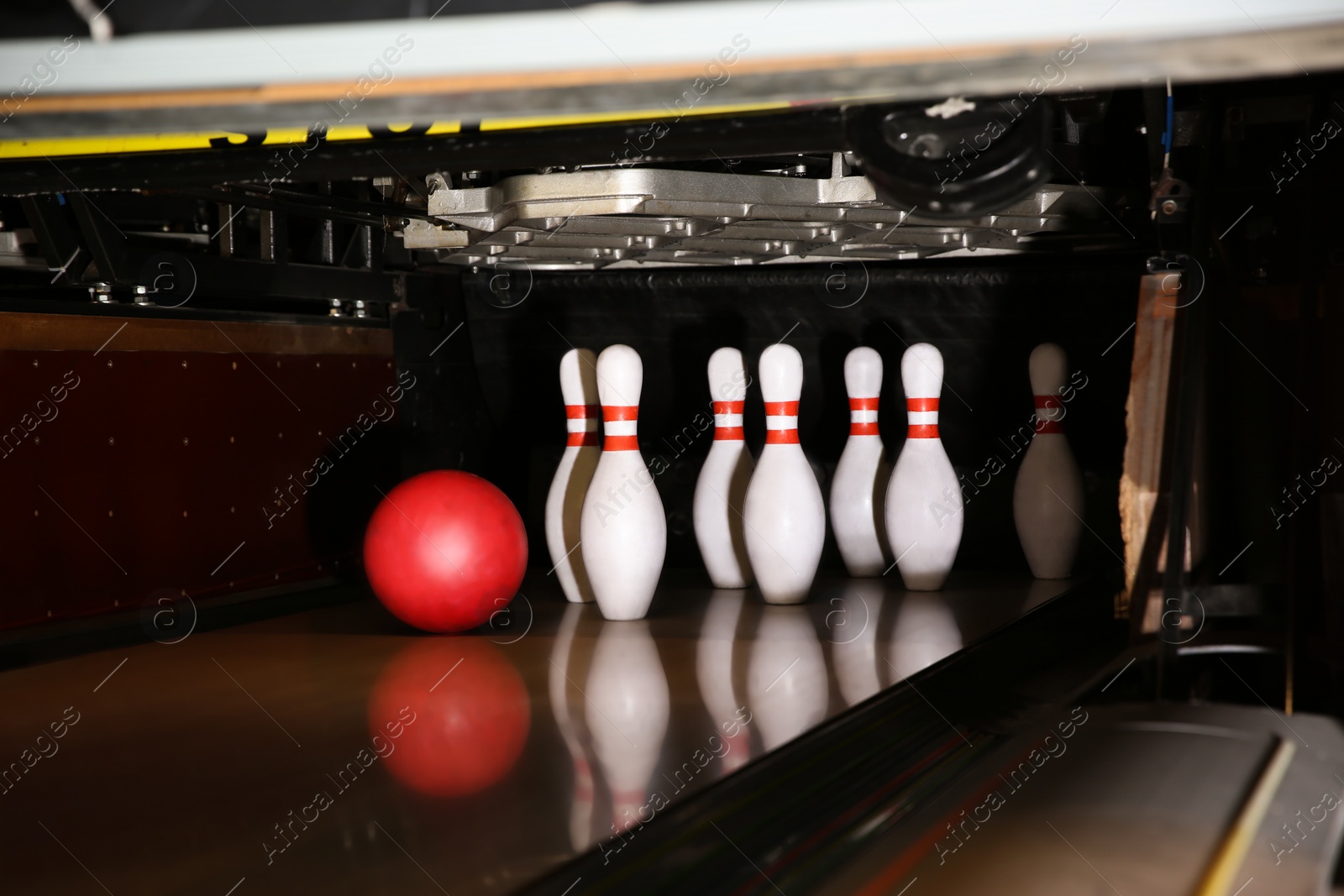 Photo of Ball and pins on alley in bowling club