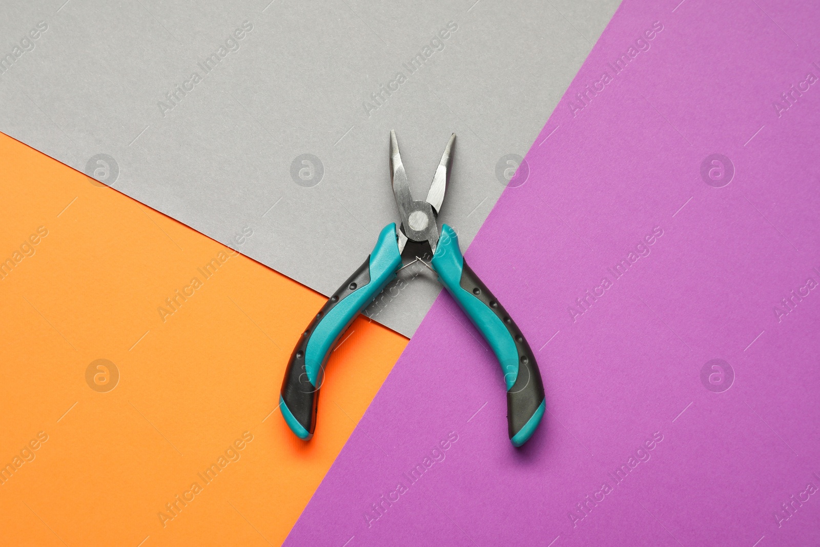 Photo of Bent nose pliers on color background, top view