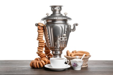 Samovar with hot tea, jam and delicious ring shaped Sushki (dry bagels) on table against white background