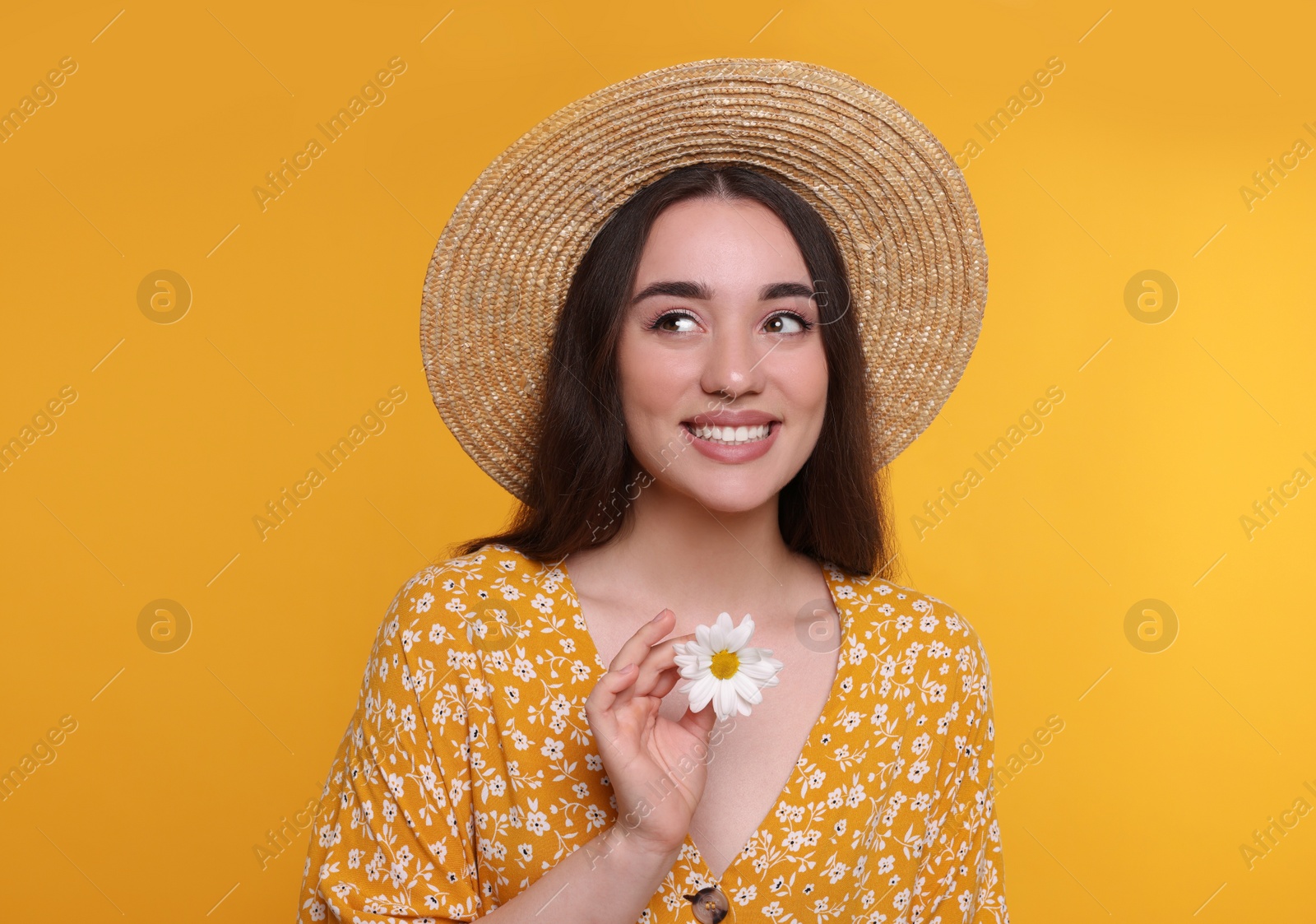 Photo of Beautiful woman with spring flower in hand on yellow background