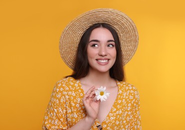 Photo of Beautiful woman with spring flower in hand on yellow background