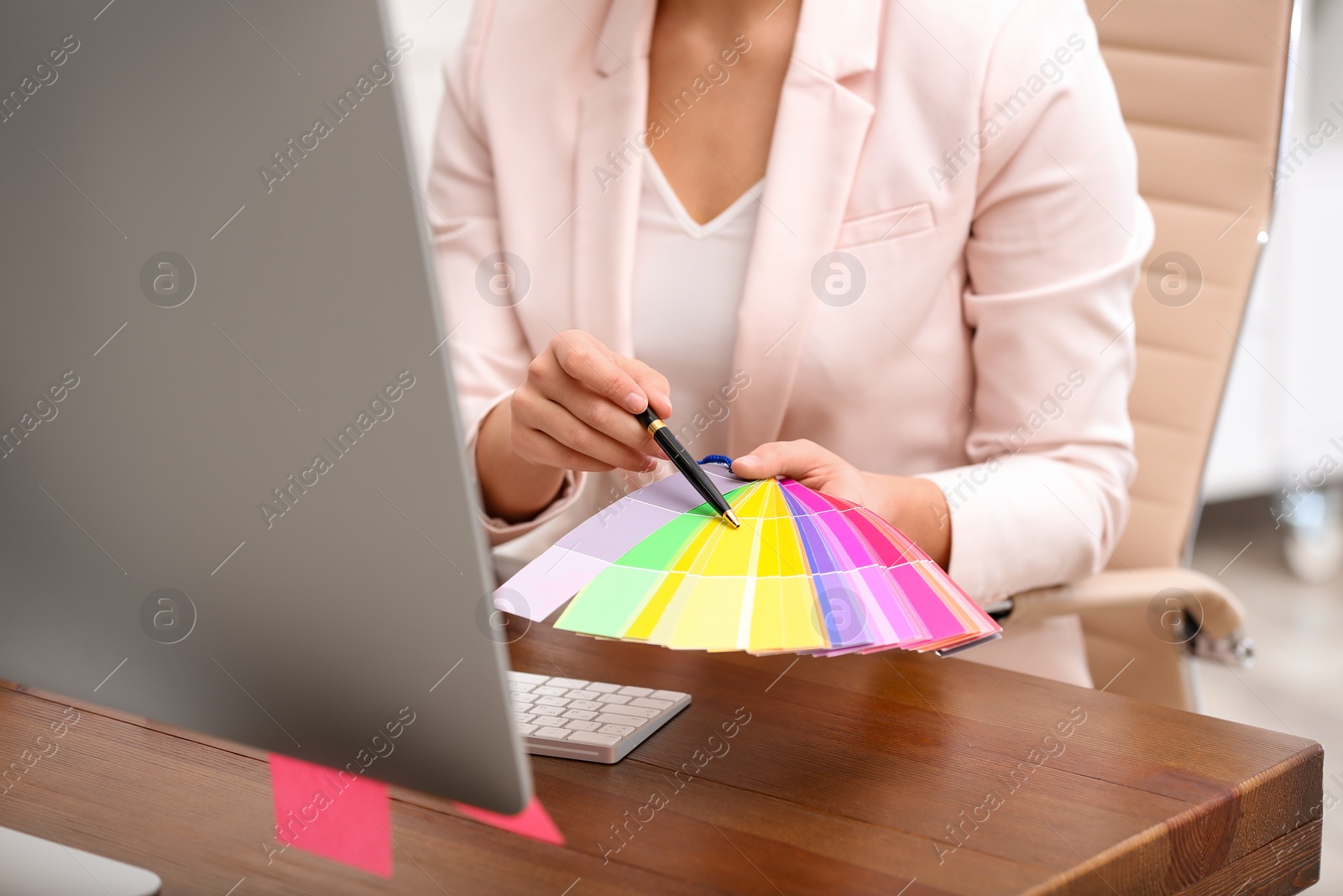 Photo of Female designer working at desk in office, closeup