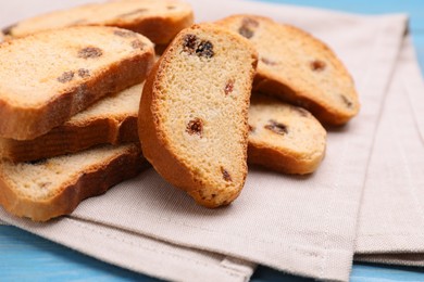 Photo of Sweet hard chuck crackers with raisins on light blue wooden table, closeup