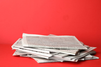 Photo of Stack of newspapers on red background. Journalist's work