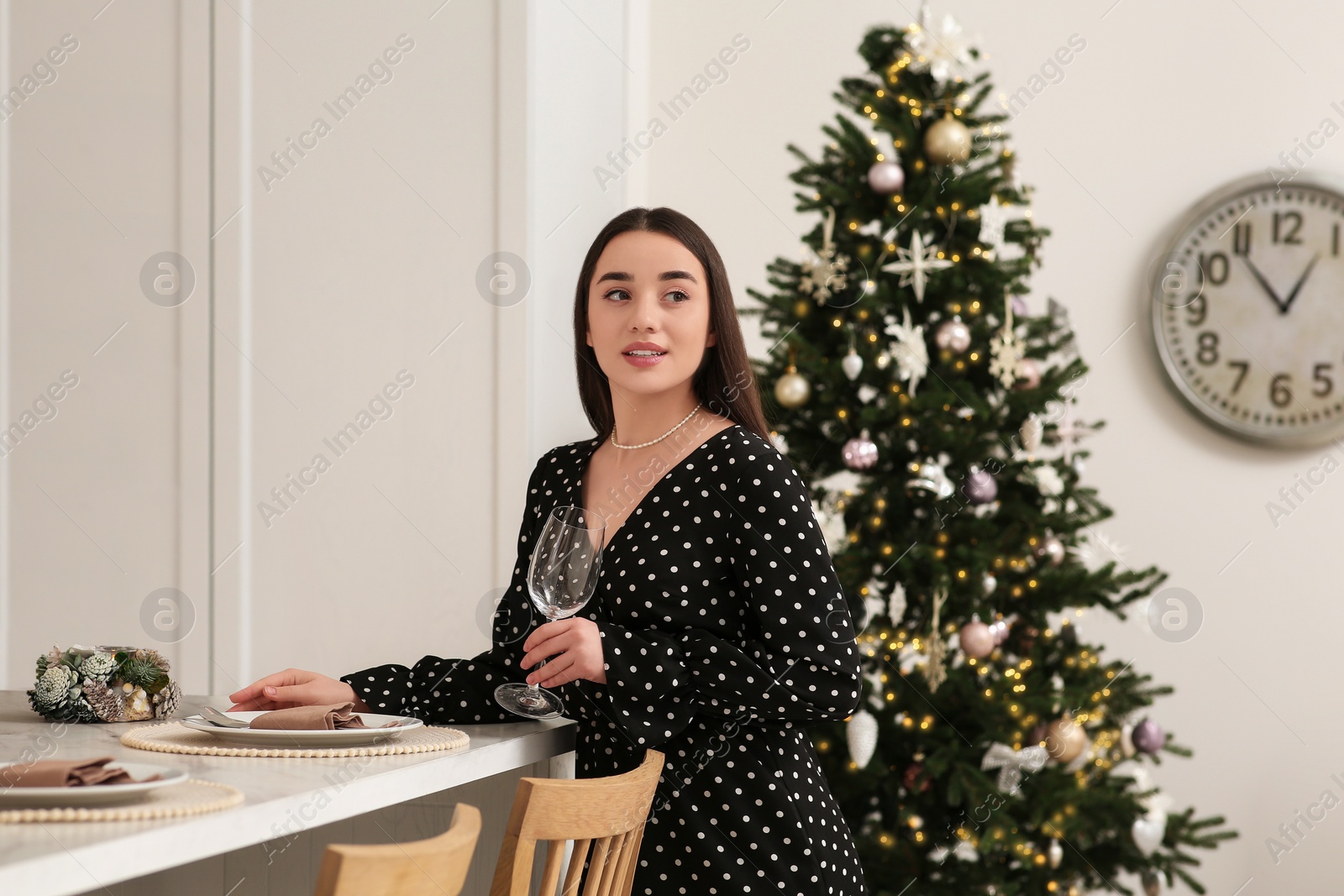 Photo of Beautiful woman serving table for Christmas in kitchen