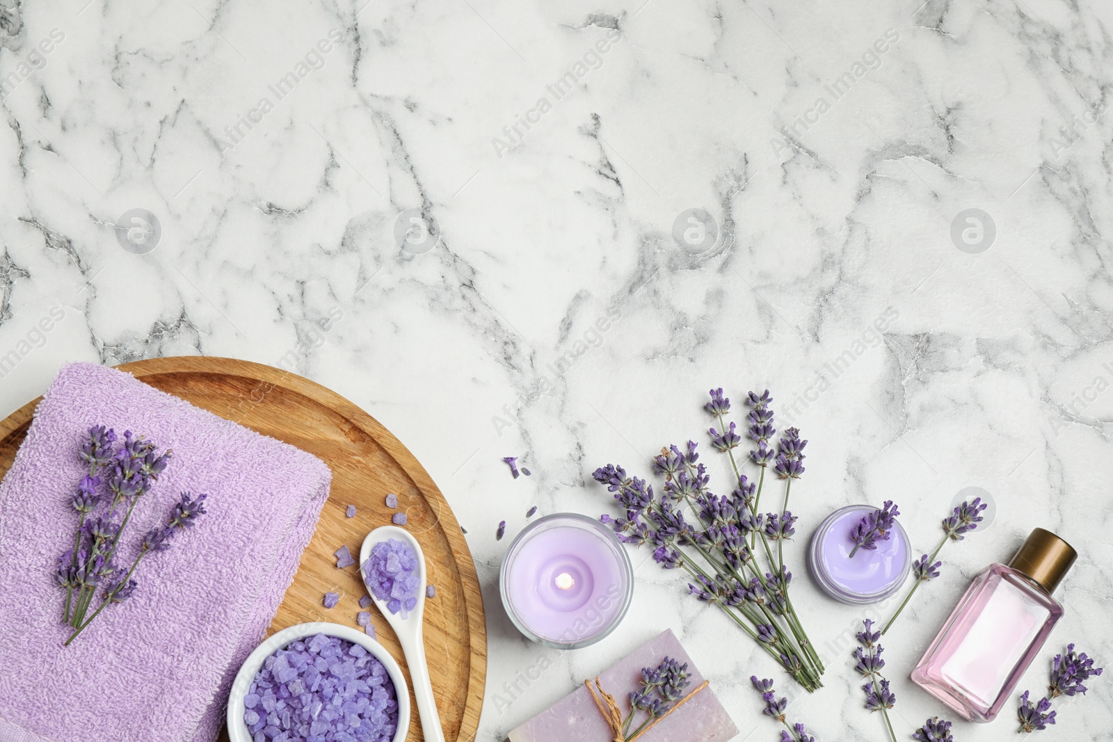 Photo of Cosmetic products and lavender flowers on white marble table, flat lay. Space for text