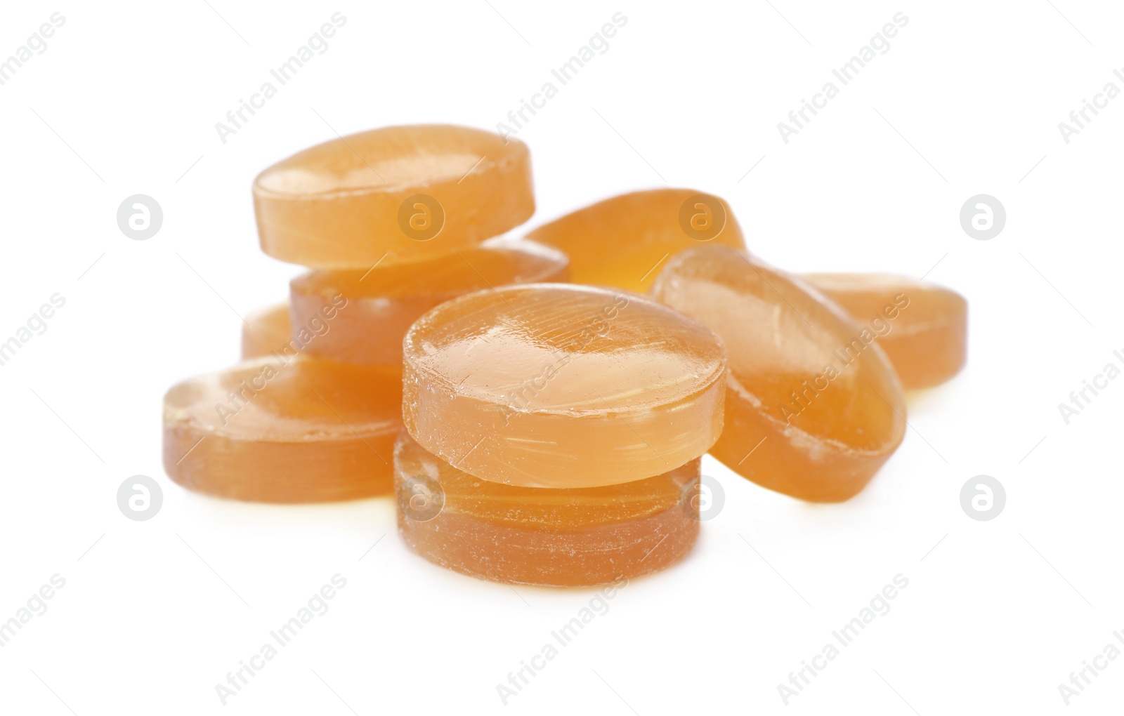 Photo of Many yellow cough drops on white background