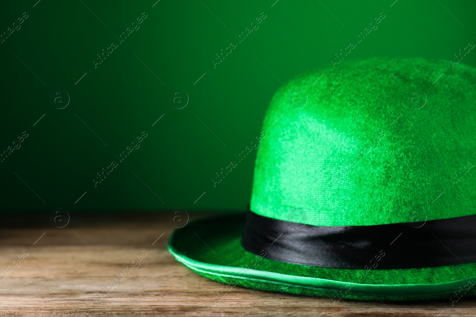 Photo of Green leprechaun hat on wooden table, closeup. St. Patrick's Day celebration