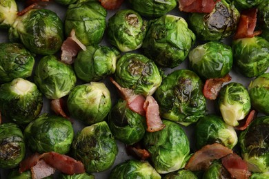 Photo of Delicious roasted Brussels sprouts and bacon as background, top view