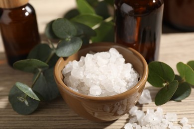 Photo of Composition with spa products and eucalyptus leaves on wooden table, closeup