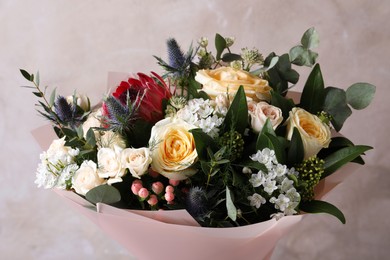 Photo of Beautiful bouquet with roses on beige background