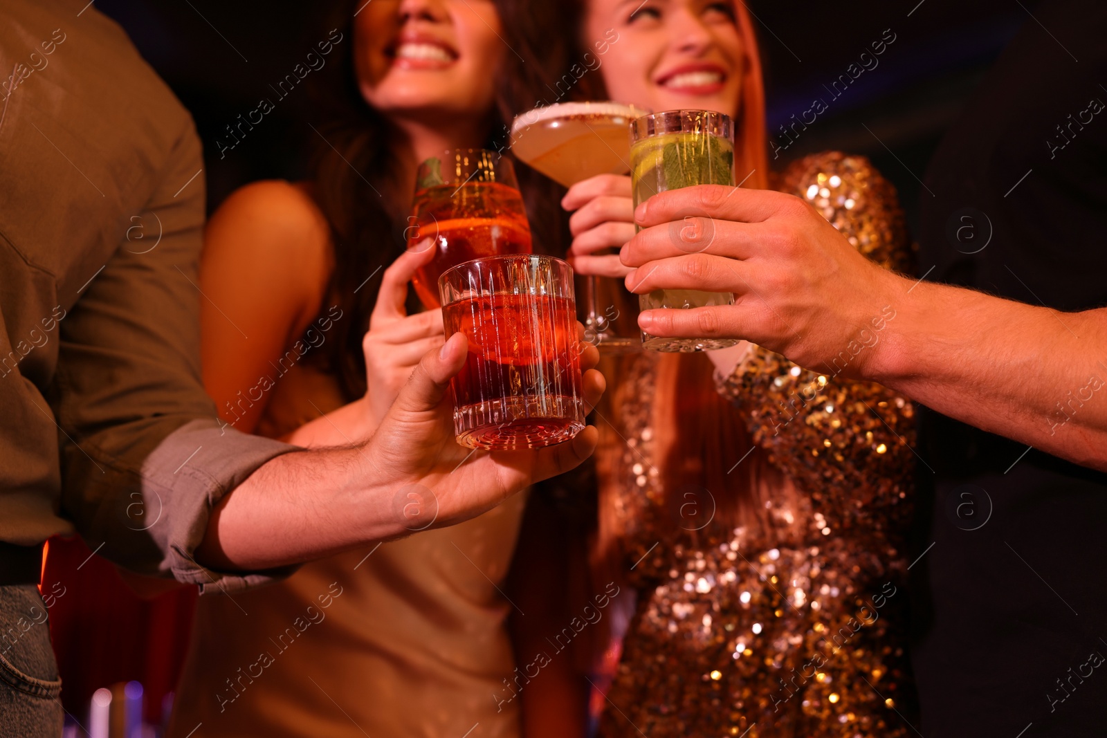 Photo of Friends clinking glasses with fresh cocktails, closeup