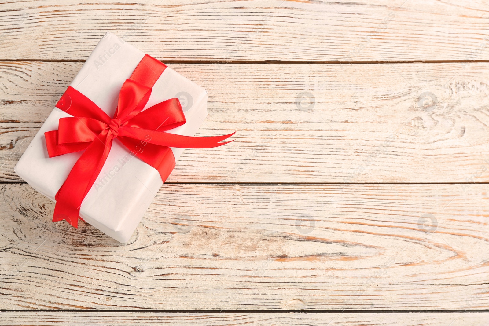 Photo of Elegant gift box with bow on wooden background, top view