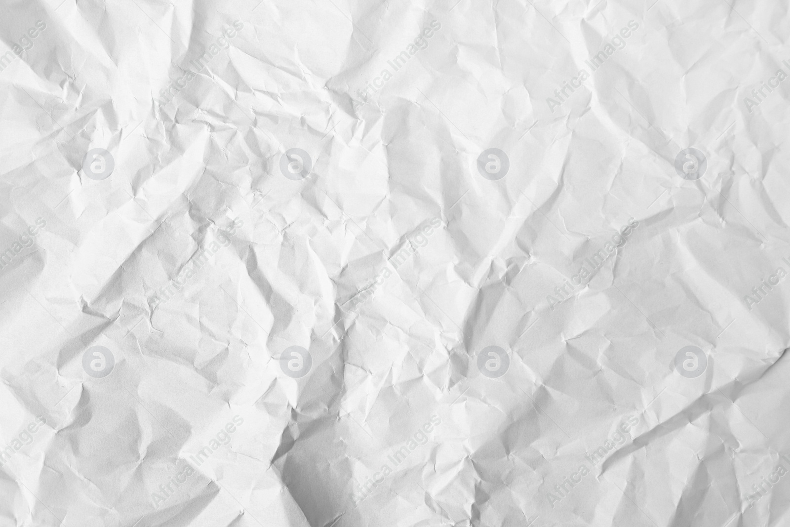 Photo of Sheet of crumpled paper white as background, top view