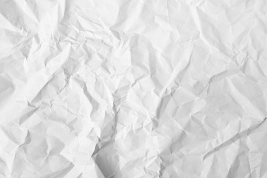 Sheet of crumpled paper white as background, top view