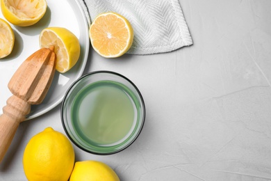 Flat lay composition with freshly squeezed lemon juice on table. Space for text