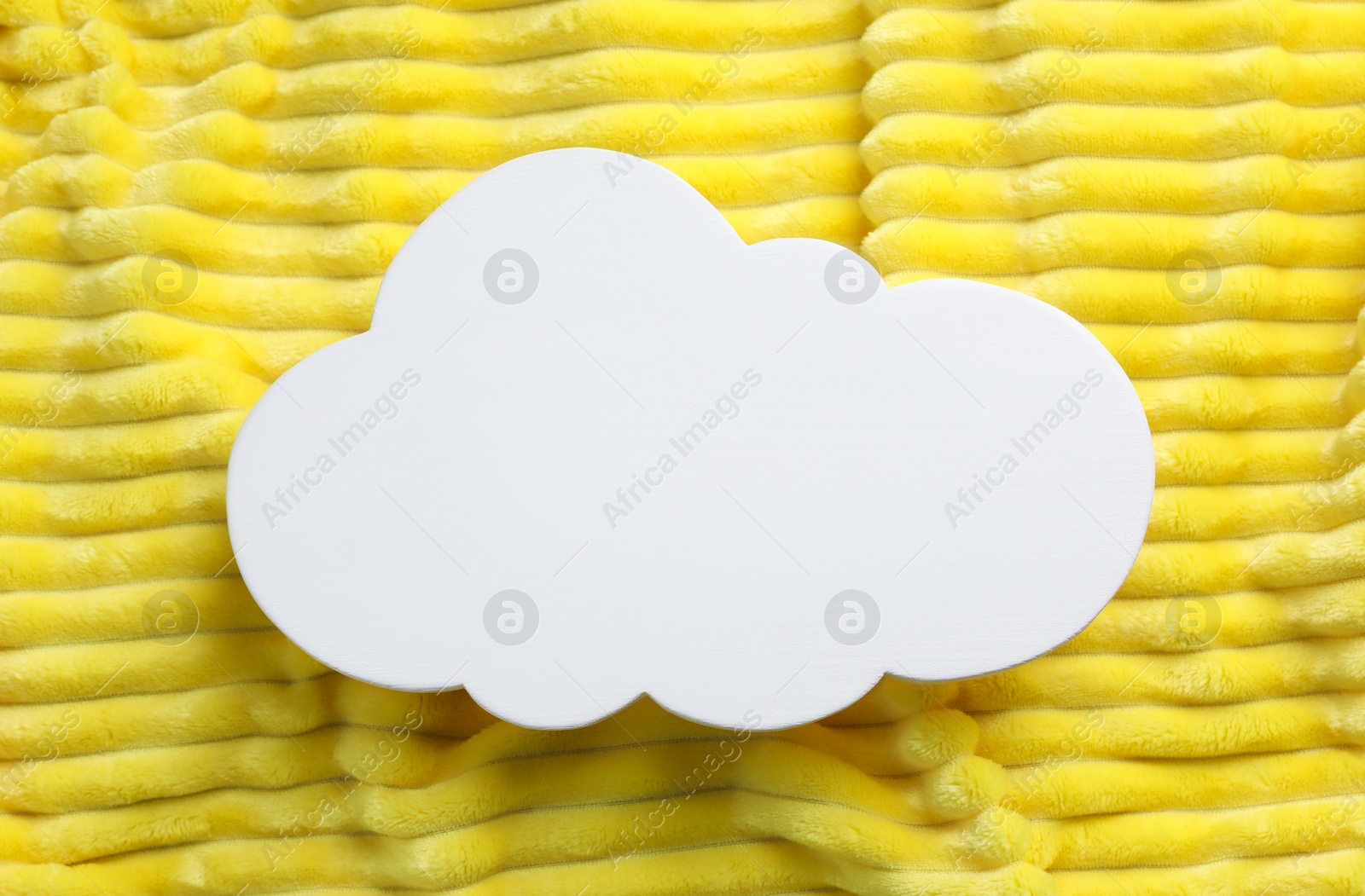 Photo of Cloud shaped child's night lamp on yellow fabric, top view