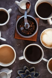 Photo of Cups of fresh aromatic coffee on grey background, top view