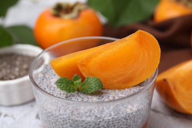 Photo of Delicious dessert with persimmon and chia seeds, closeup