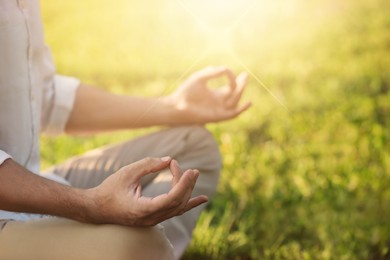 Image of Man meditating outdoors on sunny day, closeup. Practicing yoga