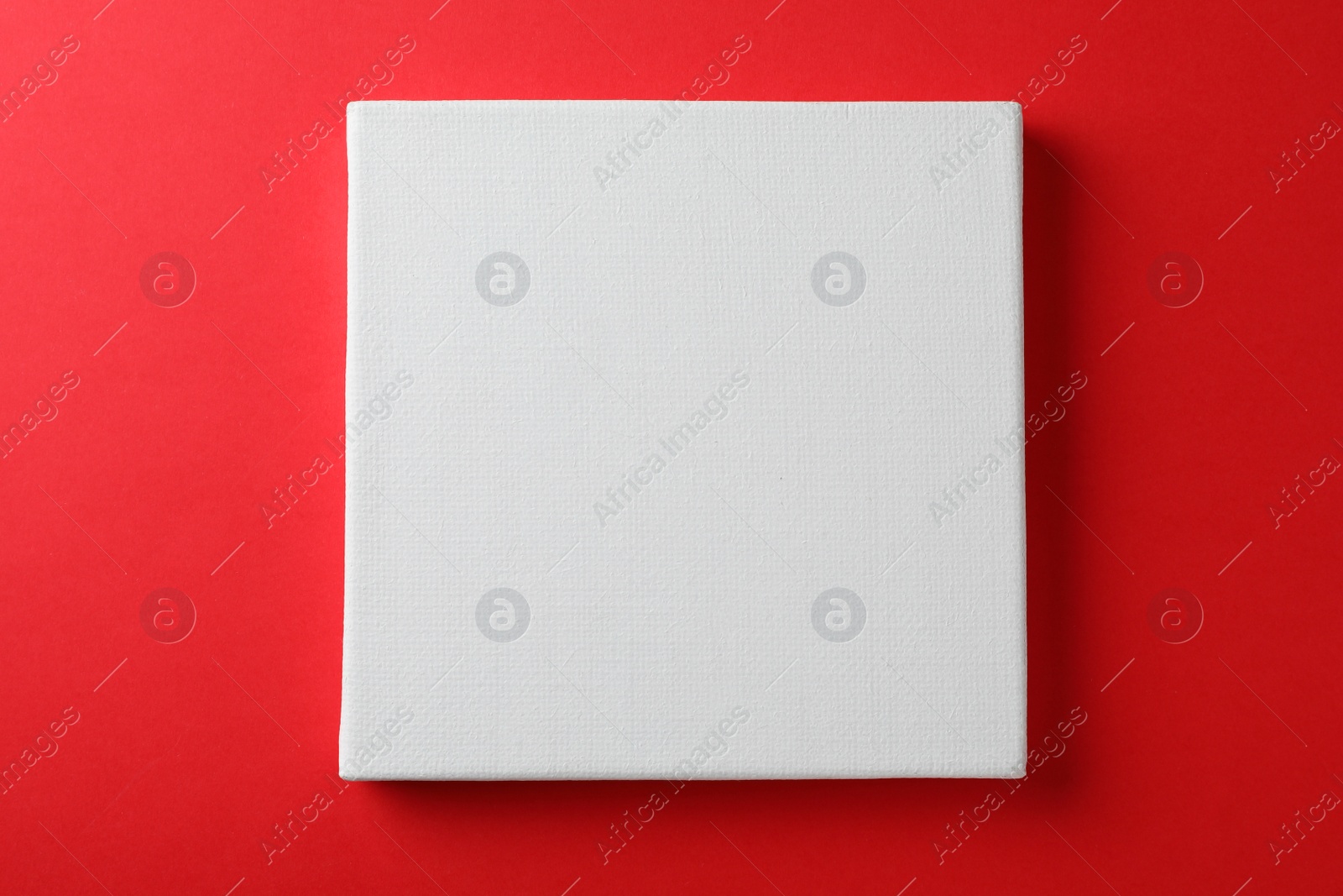 Photo of Blank canvas on red background, space for text