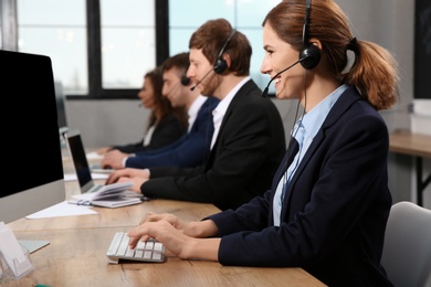 Photo of Team of technical support with headsets at workplace