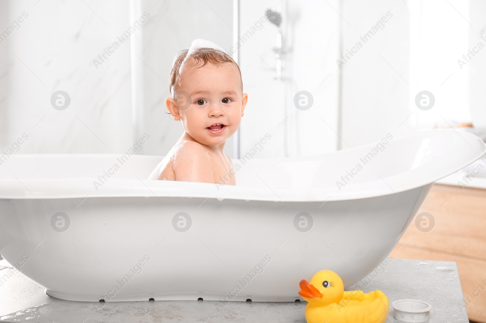 Photo of Cute little baby in bathtub at home