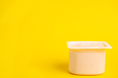 Photo of Tasty organic yogurt on yellow background. Space for text