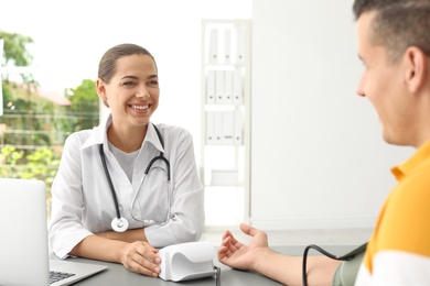 Doctor checking patient's blood pressure in hospital