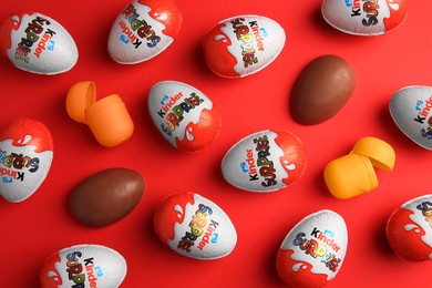 Photo of Sveti Vlas, Bulgaria - June 27, 2023: Kinder Surprise Eggs and plastic containers on red background, flat lay