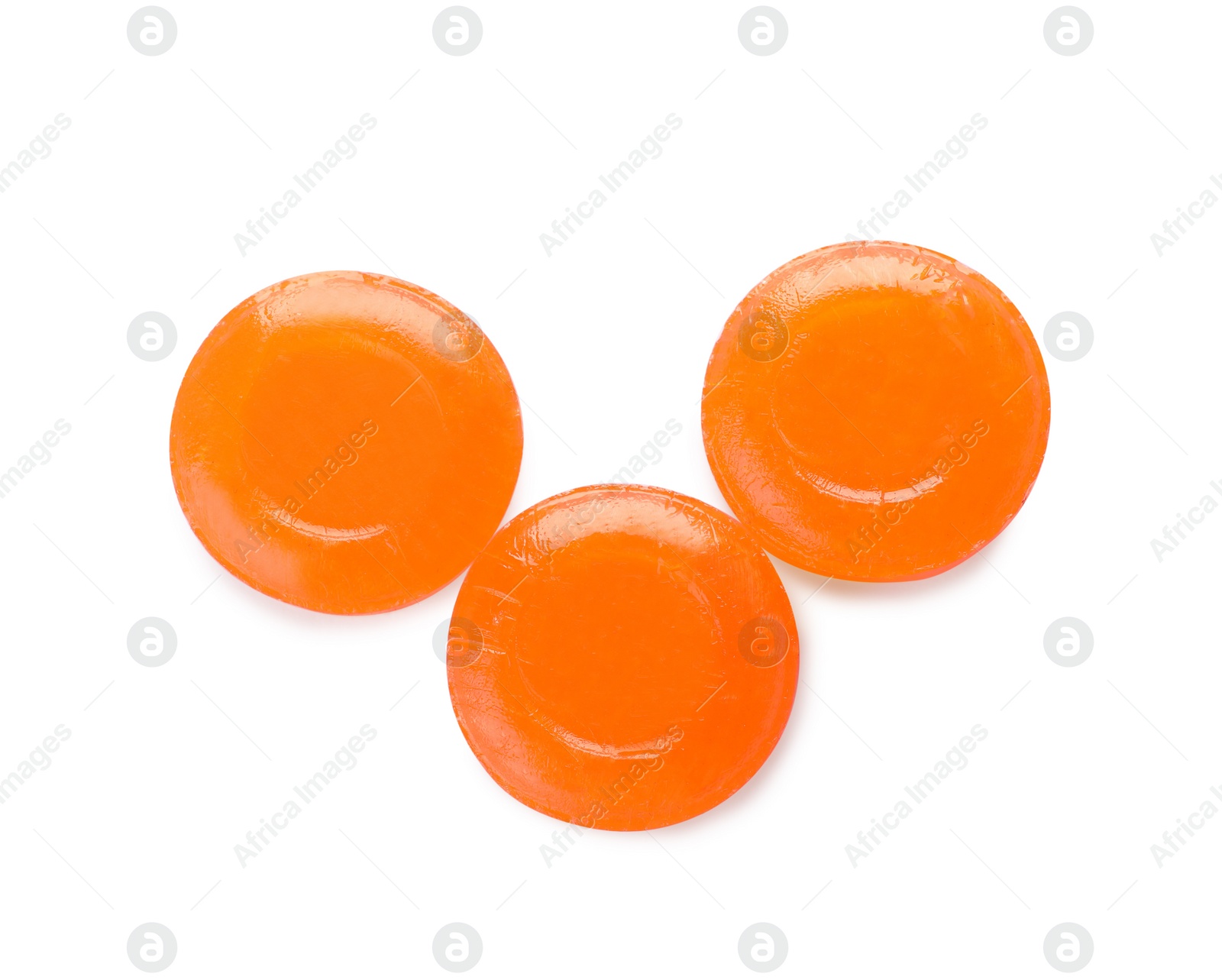 Photo of Three orange cough drops on white background, top view