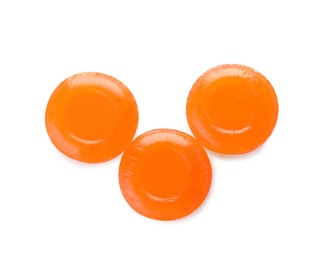 Photo of Three orange cough drops on white background, top view