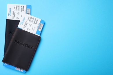 Photo of Passports with avia tickets on light blue background, flat lay with space for text. Travel agency concept