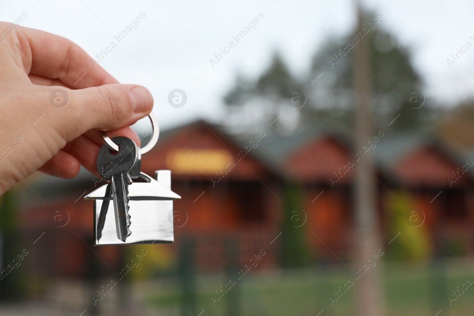 Photo of Woman holding house keys outdoors, closeup with space for text. Real estate agent