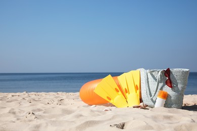 Photo of Bag and beach accessories on seaside. Space for text