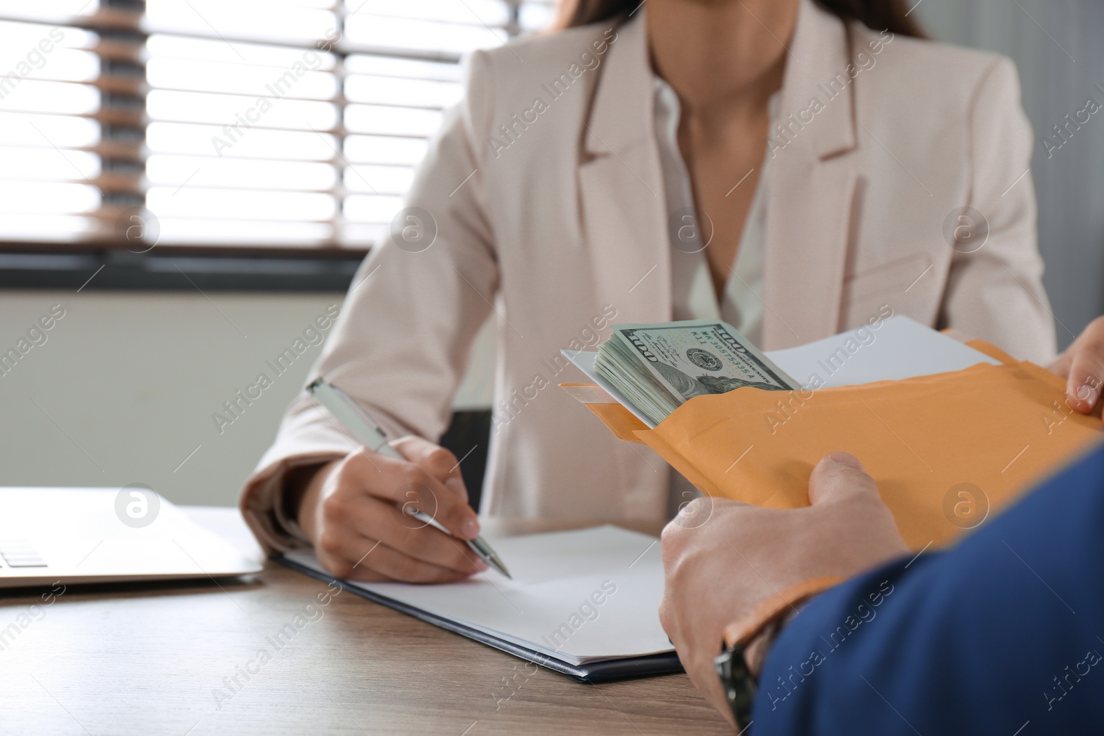 Photo of Man giving bribe to woman at table, closeup