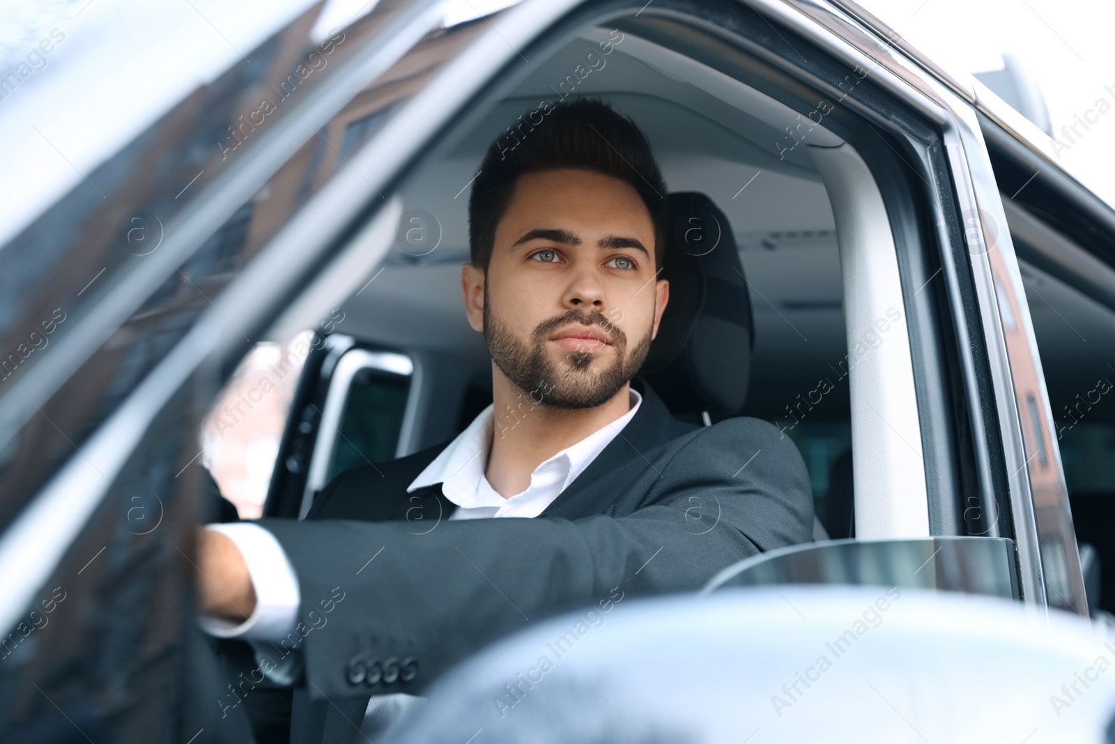 Photo of Handsome young man driving his modern car