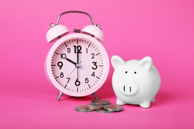 Photo of Ceramic piggy bank, coins and alarm clock on pink background. Financial savings