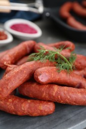 Photo of Delicious sausages and dill on grey table, closeup
