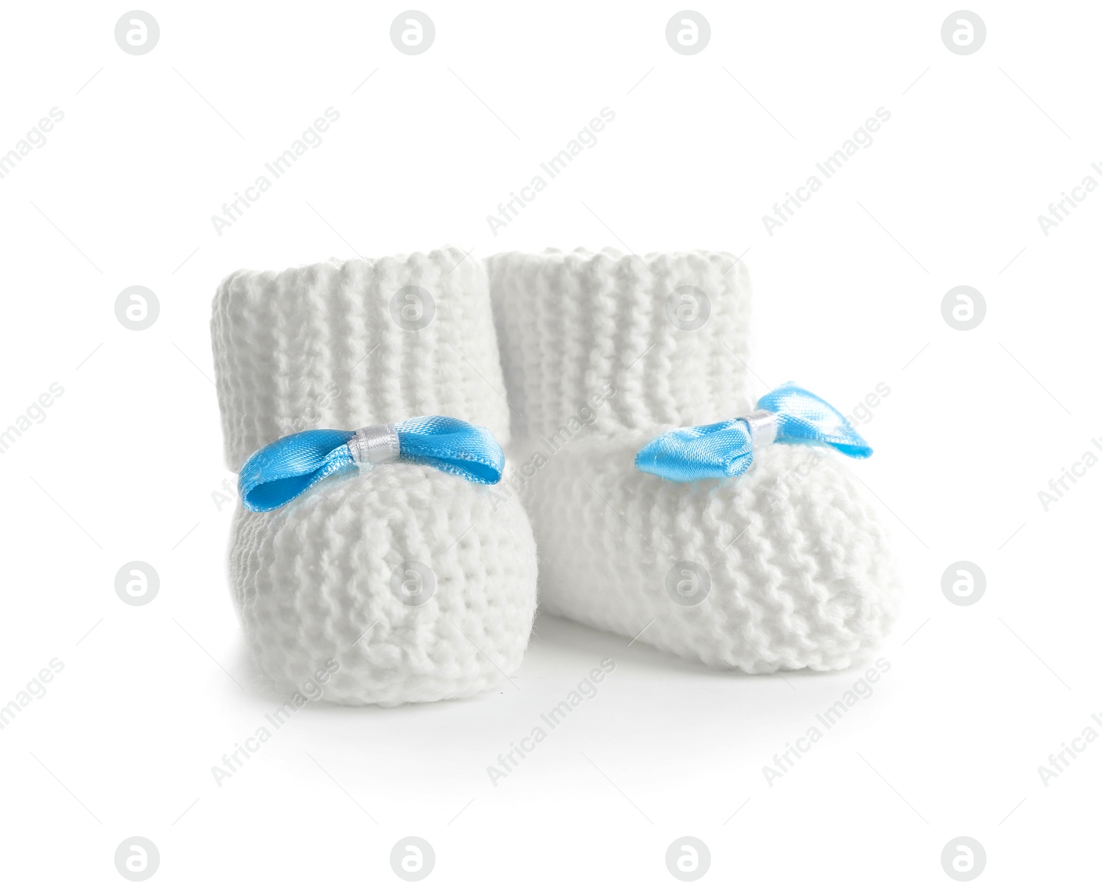 Photo of Handmade baby booties with bows isolated on white