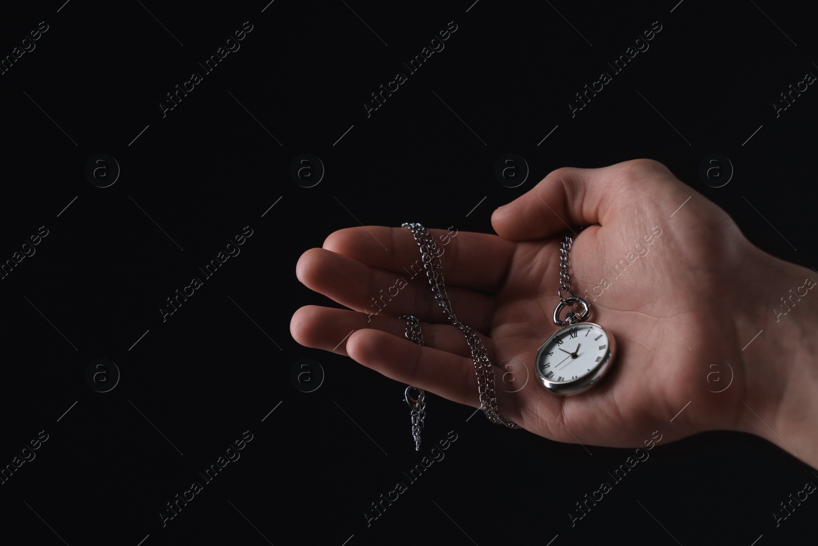 Photo of Man holding chain with elegant pocket watch on black background, closeup. Space for text