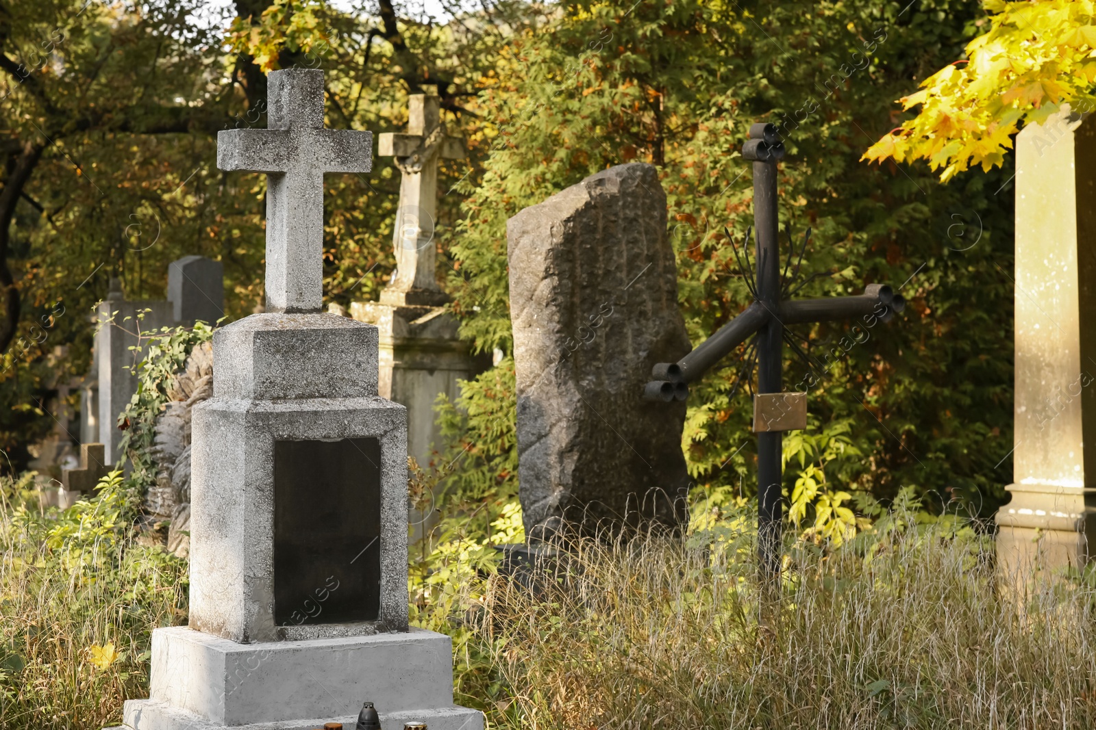 Photo of Granite tombstone with cross on cemetery. Funeral ceremony